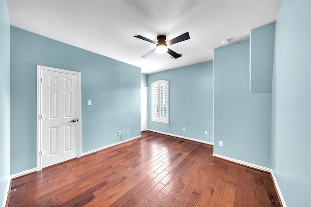 spare room featuring baseboards, a textured ceiling, ceiling fan, and wood finished floors
