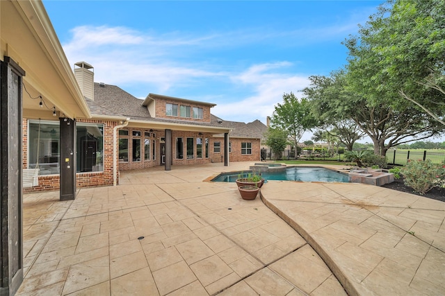 view of swimming pool with a pool with connected hot tub, fence, and a patio area