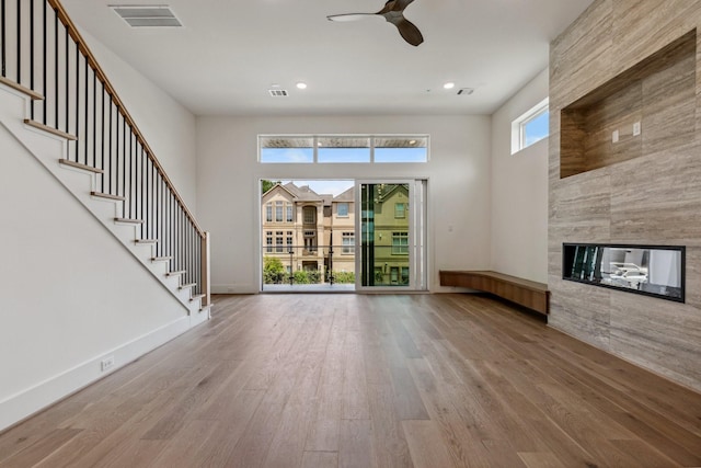 4705 Gibson St, Houston, TX 77007 - unfurnished living room featuring wood finished floors, ceiling fan, a fireplace, stairway, and recessed lighting