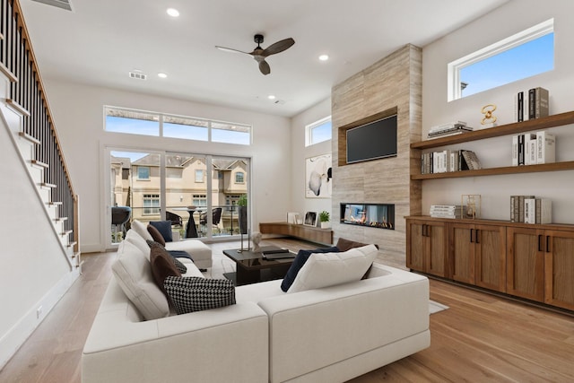 4705 Gibson St, Houston, TX 77007 - living area featuring ceiling fan, light wood-style flooring, a tile fireplace, recessed lighting, and stairs