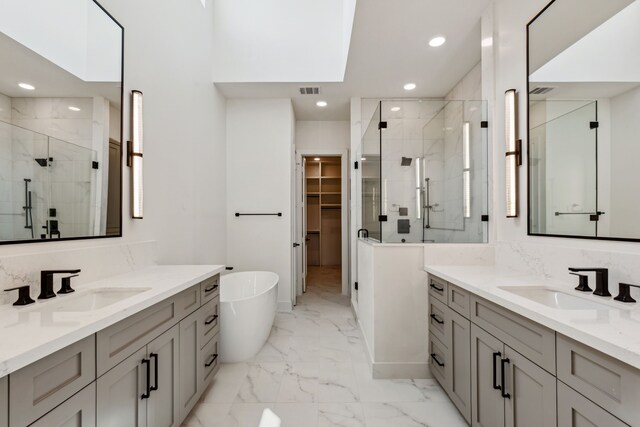 4705 Gibson St, Houston, TX 77007 - bathroom featuring a stall shower, marble finish flooring, recessed lighting, a freestanding bath, and two vanities