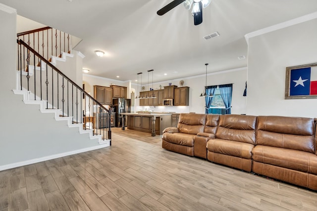 717 Willowbranch Ln, Midlothian, TX 76065 - living room featuring a ceiling fan, visible vents, ornamental molding, and light wood-style flooring