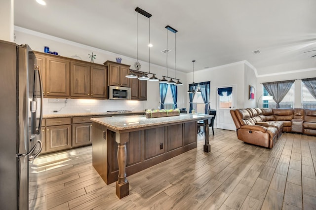 717 Willowbranch Ln, Midlothian, TX 76065 - kitchen with crown molding, a breakfast bar, open floor plan, light stone counters, and stainless steel appliances