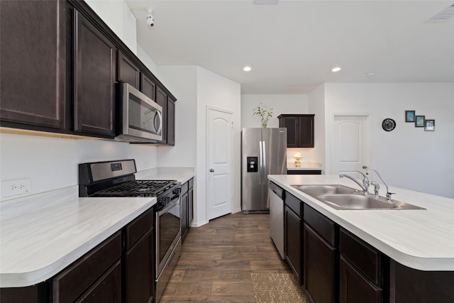 kitchen featuring dark wood-style floors, a sink, appliances with stainless steel finishes, and light countertops