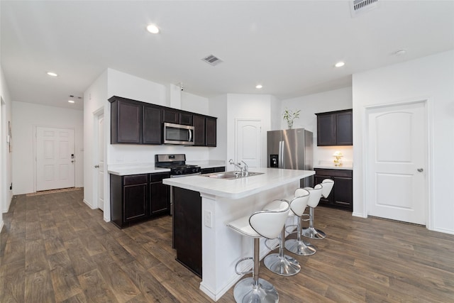 kitchen with dark wood finished floors, visible vents, appliances with stainless steel finishes, and a sink