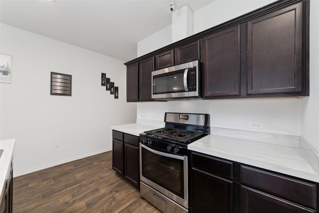 kitchen with dark brown cabinetry, dark wood finished floors, appliances with stainless steel finishes, and light countertops