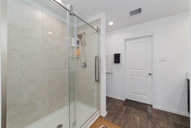 bathroom featuring visible vents, a shower stall, wood finished floors, and baseboards