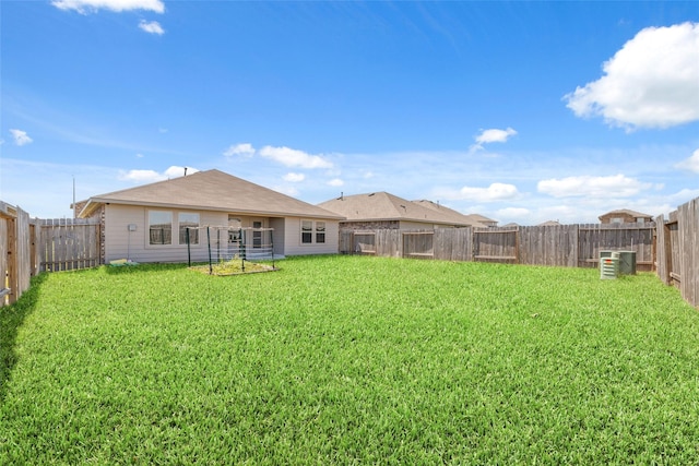 rear view of house with a fenced backyard and a lawn