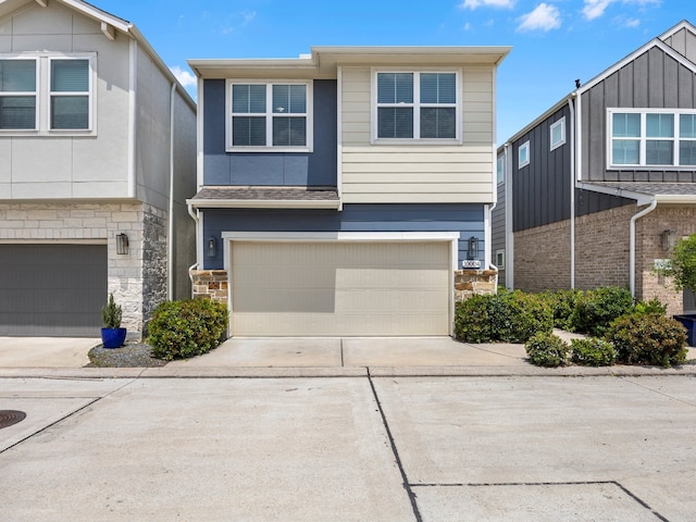 view of front of house featuring driveway, stone siding, and a garage