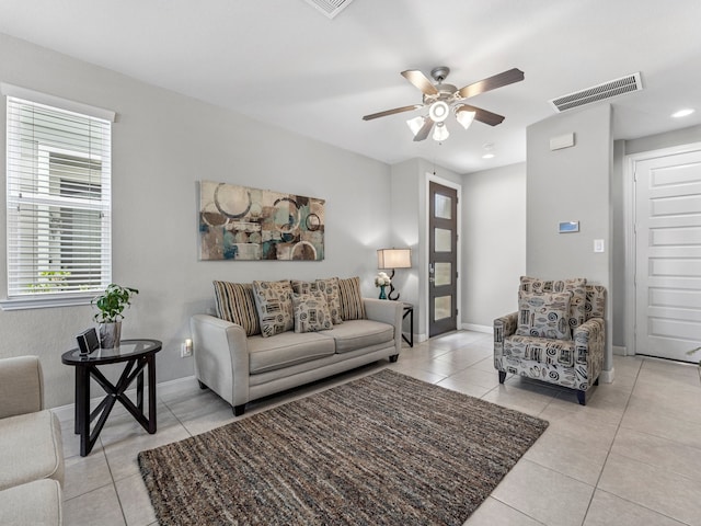 living room featuring baseboards, ceiling fan, visible vents, and light tile patterned floors