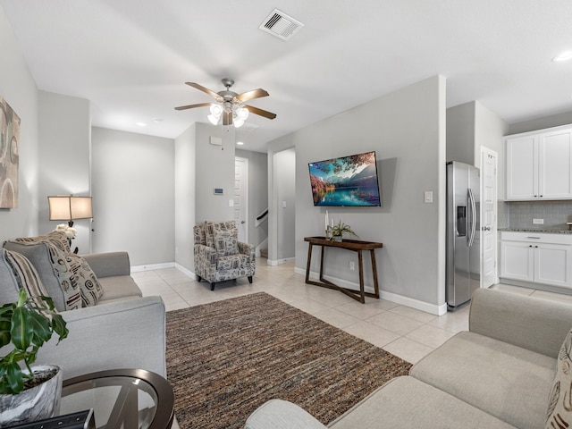 living room with visible vents, a ceiling fan, baseboards, and light tile patterned flooring