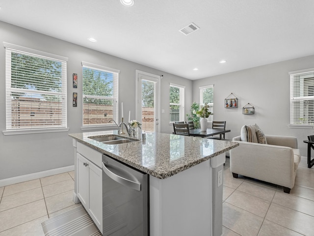 kitchen with visible vents, light tile patterned flooring, a center island with sink, a sink, and dishwasher