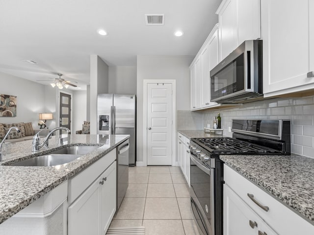 kitchen with visible vents, a sink, decorative backsplash, and appliances with stainless steel finishes