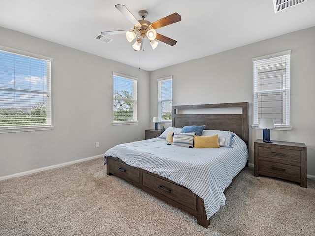 carpeted bedroom featuring visible vents, a ceiling fan, and baseboards