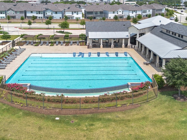 community pool featuring fence, a patio area, and a residential view