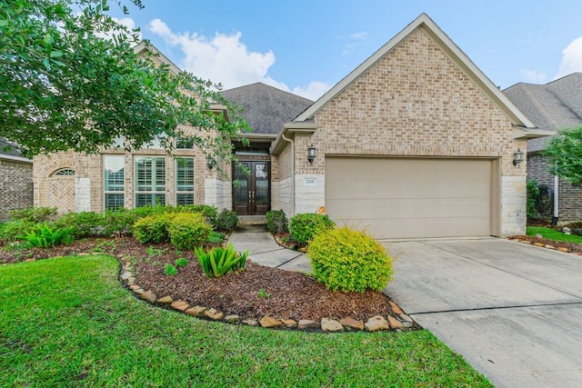 2116 Nogalas Ln, League City, TX 77573 - view of front of house featuring driveway, a shingled roof, an attached garage, french doors, and brick siding