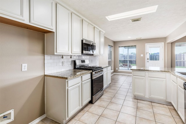 1918 N Everglades Dr, Deer Park, TX 77536 - kitchen featuring light stone counters, a textured ceiling, tasteful backsplash, visible vents, and stainless steel appliances
