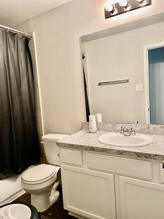 985 Harper Ln, Bryan, TX 77803 - full bathroom featuring vanity, toilet, a textured wall, and shower / bathtub combination with curtain