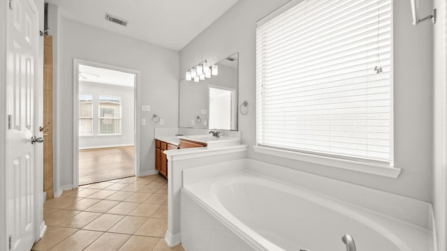 full bath featuring a garden tub, vanity, tile patterned floors, and baseboards