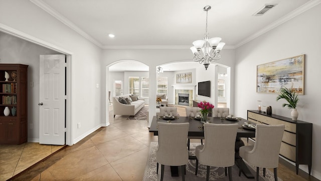 dining space featuring tile patterned flooring, a chandelier, visible vents, ornamental molding, and arched walkways