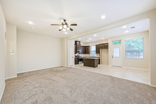 unfurnished living room with a ceiling fan, light carpet, plenty of natural light, and recessed lighting