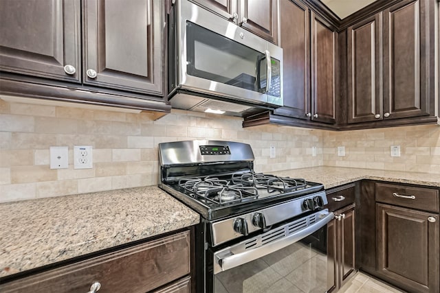 kitchen featuring stainless steel appliances, backsplash, and dark brown cabinetry