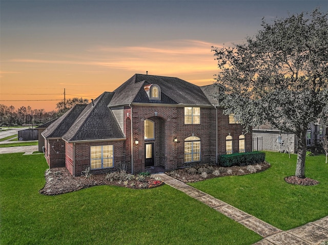 view of front facade featuring a lawn and brick siding