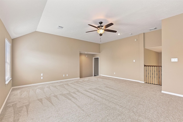 carpeted spare room featuring visible vents, a ceiling fan, baseboards, and vaulted ceiling