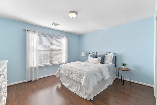 bedroom with dark wood-style flooring, baseboards, and visible vents
