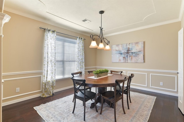 dining room with visible vents, crown molding, hardwood / wood-style flooring, and ornate columns