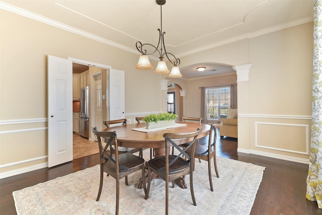 dining room with crown molding, arched walkways, and dark wood-style floors