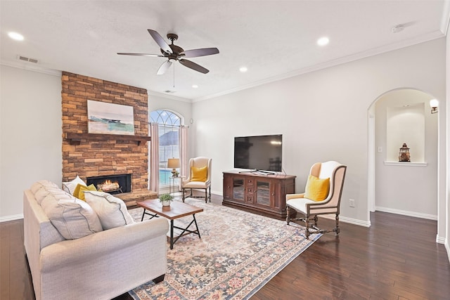 living area with arched walkways, ceiling fan, baseboards, and visible vents