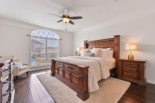 bedroom with a ceiling fan, a textured ceiling, ornamental molding, and dark wood-type flooring