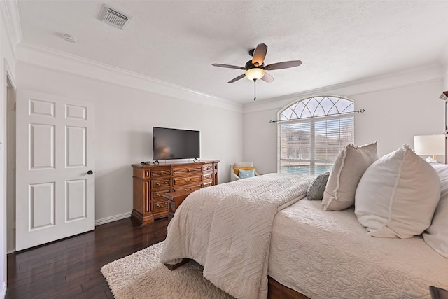 bedroom with dark wood finished floors, a ceiling fan, baseboards, visible vents, and ornamental molding