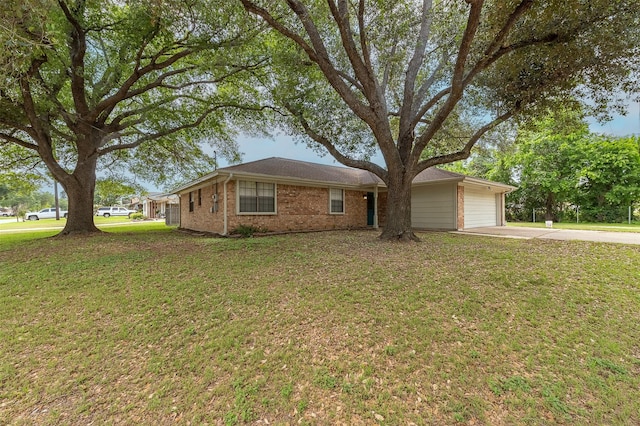 ranch-style home featuring concrete driveway, a front yard, brick siding, and a garage