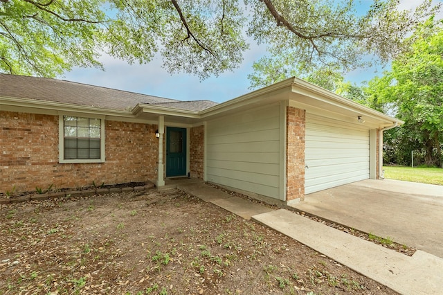 view of front of property with driveway, brick siding, a shingled roof, and an attached garage