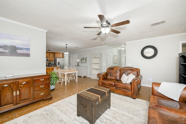 923 N Hull St, Caldwell, TX 77836 - living room featuring a ceiling fan, crown molding, light tile patterned floors, and a textured ceiling