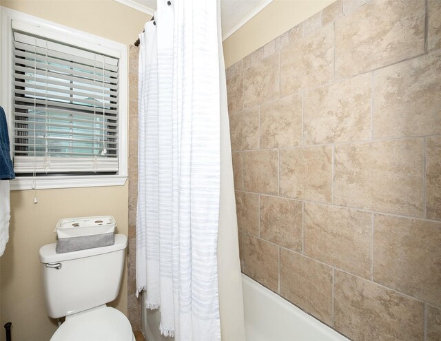 full bath featuring toilet, ornamental molding, and shower / tub combo