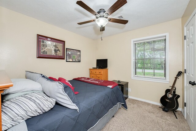 bedroom with baseboards, visible vents, light carpet, and ceiling fan