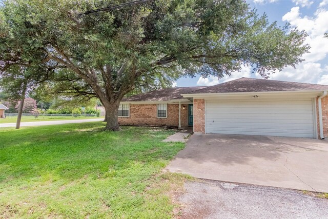 923 N Hull St, Caldwell, TX 77836 - ranch-style home with brick siding, driveway, a garage, and a front yard