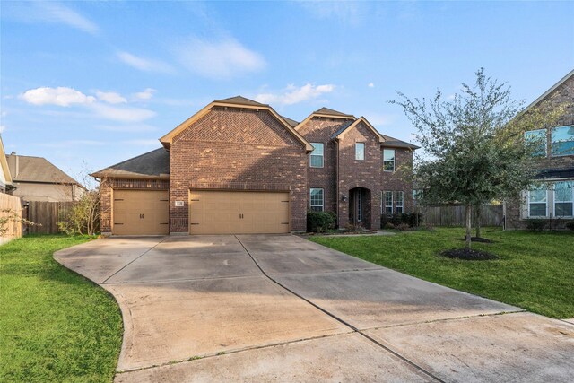 traditional-style house with a front yard, a garage, driveway, brick siding, and fence