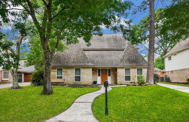 14619 Rosehill Dr, Houston, TX 77070 - view of front of home featuring roof with shingles, a front lawn, cooling unit, and brick siding