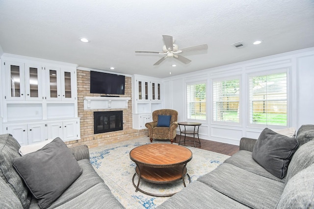 14619 Rosehill Dr, Houston, TX 77070 - living area with a ceiling fan, a brick fireplace, wood finished floors, recessed lighting, and a textured ceiling
