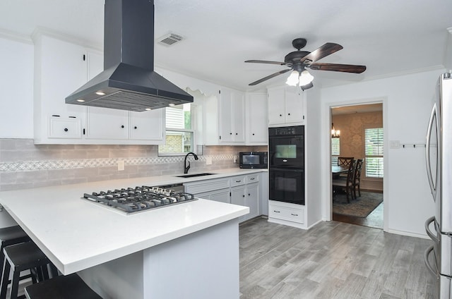 14619 Rosehill Dr, Houston, TX 77070 - kitchen with island exhaust hood, a sink, black appliances, a ceiling fan, and a peninsula