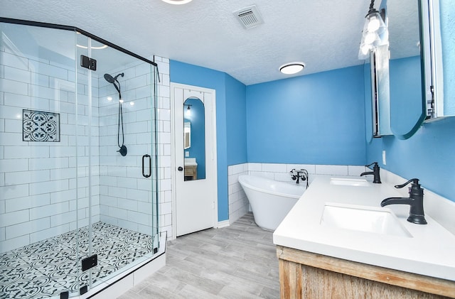 14619 Rosehill Dr, Houston, TX 77070 - bathroom featuring a shower stall, a freestanding bath, double vanity, and a textured ceiling