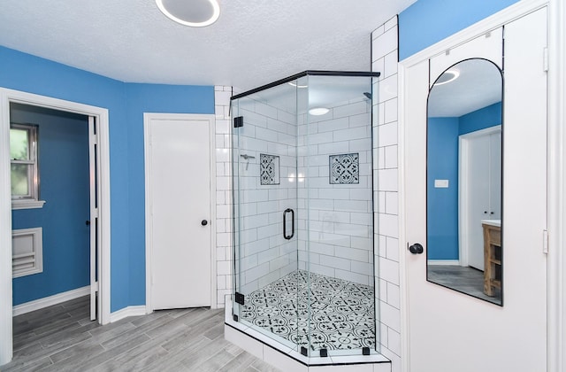 14619 Rosehill Dr, Houston, TX 77070 - full bathroom with a stall shower, wood finished floors, baseboards, and a textured ceiling