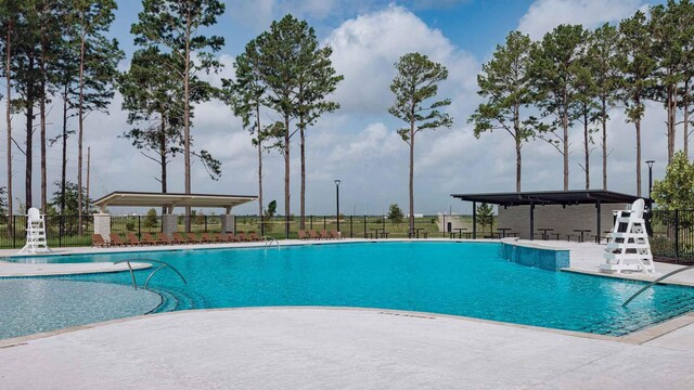 pool with a patio and fence