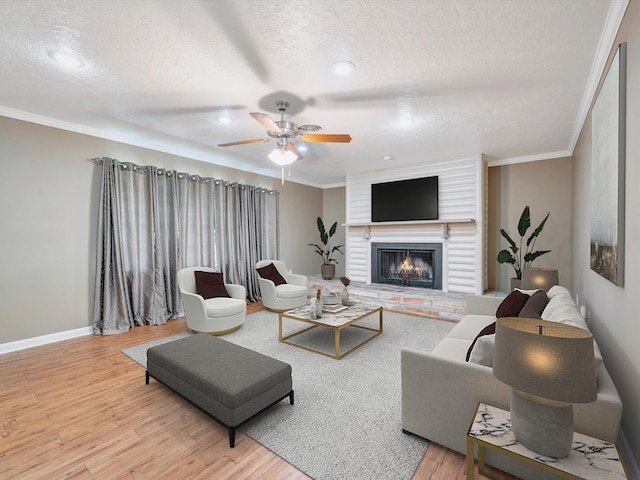 208 Burnett Dr, Baytown, TX 77520 - living room with ornamental molding, a brick fireplace, wood finished floors, a textured ceiling, and a ceiling fan