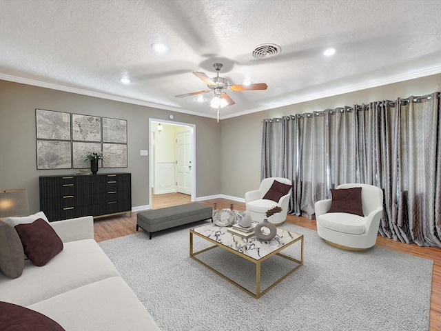 208 Burnett Dr, Baytown, TX 77520 - living area with ceiling fan, light wood-style floors, a textured ceiling, visible vents, and ornamental molding