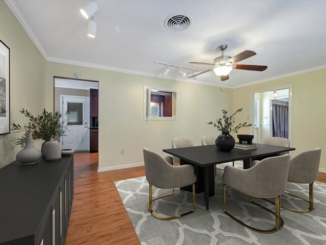 208 Burnett Dr, Baytown, TX 77520 - dining room featuring light wood-style floors, track lighting, crown molding, and visible vents